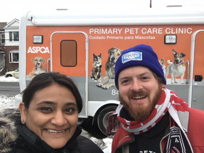 Image of two people, a woman and a man, in front of an orange van.